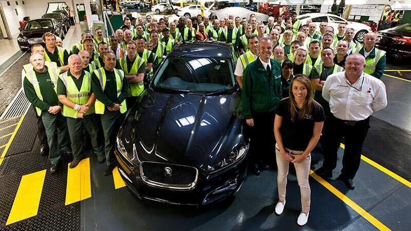 Workers with a Jaguar XJ in navy inside a factory line